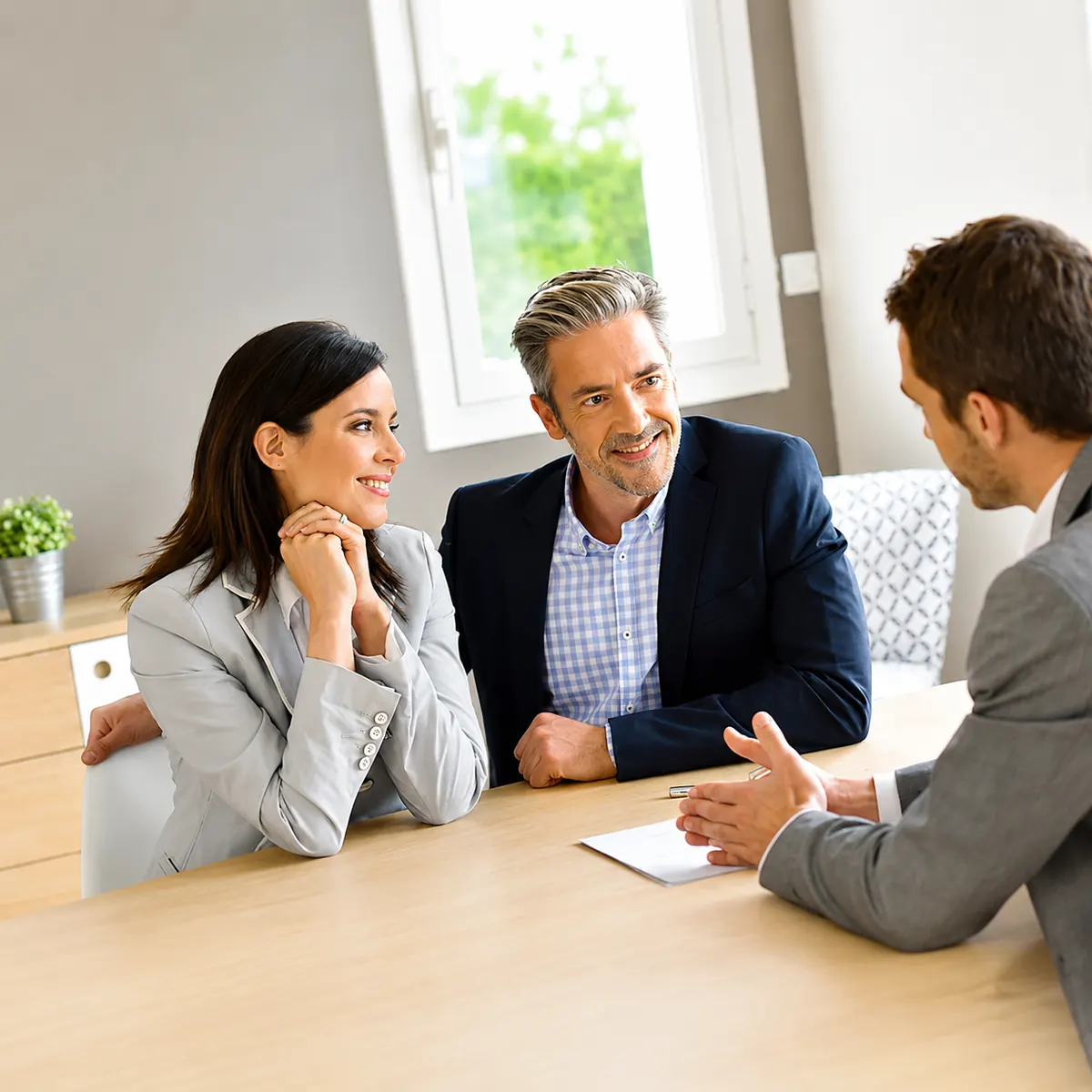 Couple souriant en rendez-vous avec un conseiller BNP PARIBAS pour un prêt professionnel